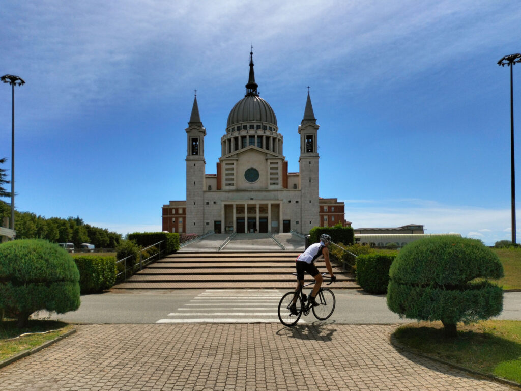 Chiesa di Castelnuovo Don Bosco con ciclista in transito in primo piano